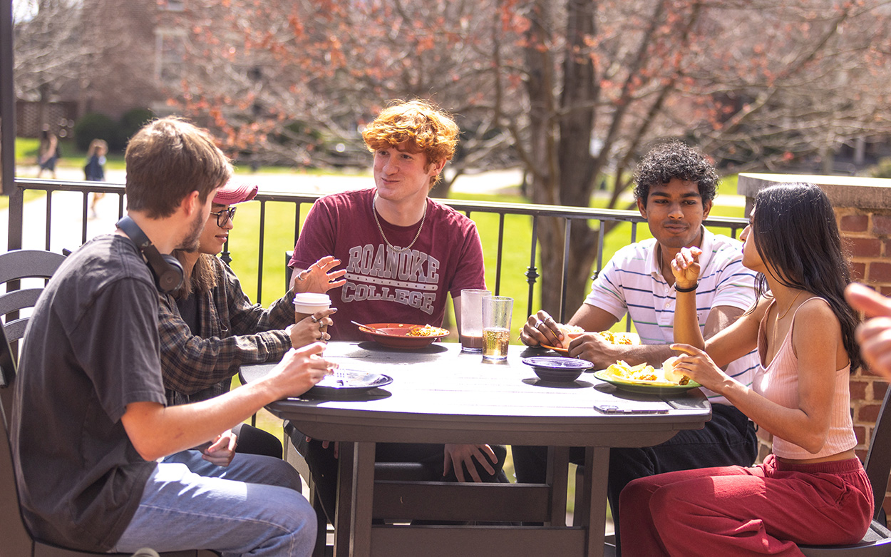 Students sitting at a table on the Sutton Commons patio