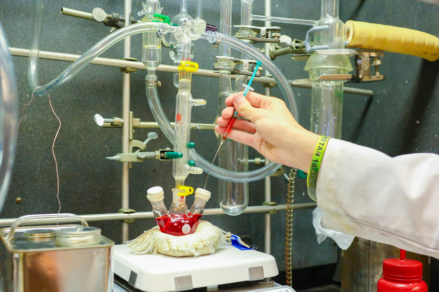 Close-up image of student's hands while working with lab equipment