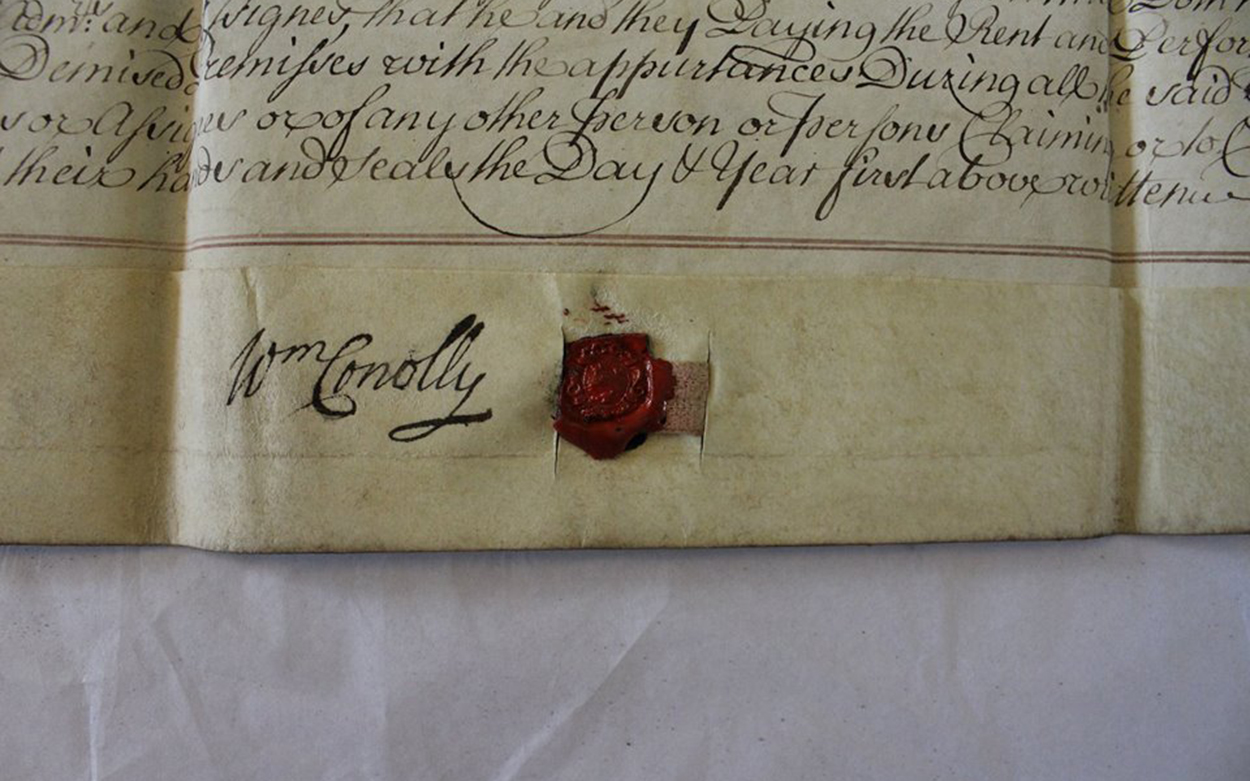 Close-up image of handwritten calligraphy on faded paper with a wax seal