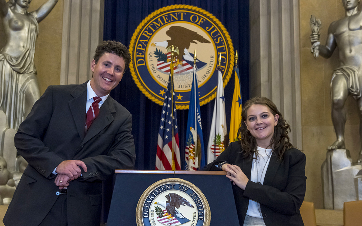 Addie Whittington '19 leaning on a podium for the U.S. Department of Justice