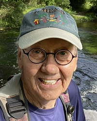 Head shot of Bob Jenkins in a green ball cap with river visible in the background. His smile makes it clear that he is really happy.