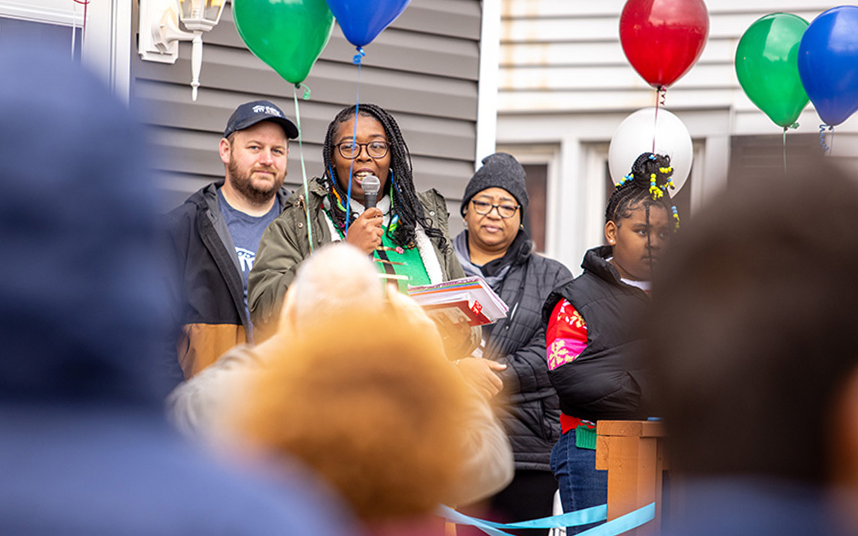 Flanked by balloons tied to her porch, Keshia Jones addresses the crowd at the dedication ceremony
