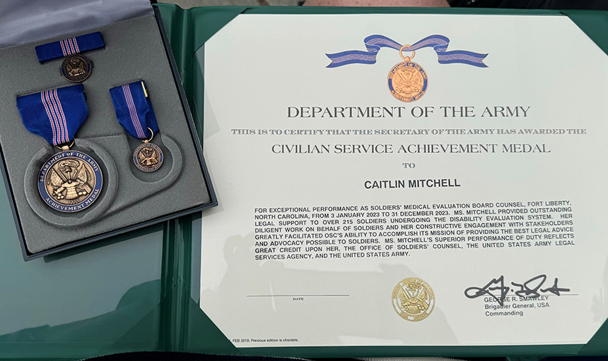 Photo of a box of military medals on blue ribbons and a certificate with the Department of Army seal on top