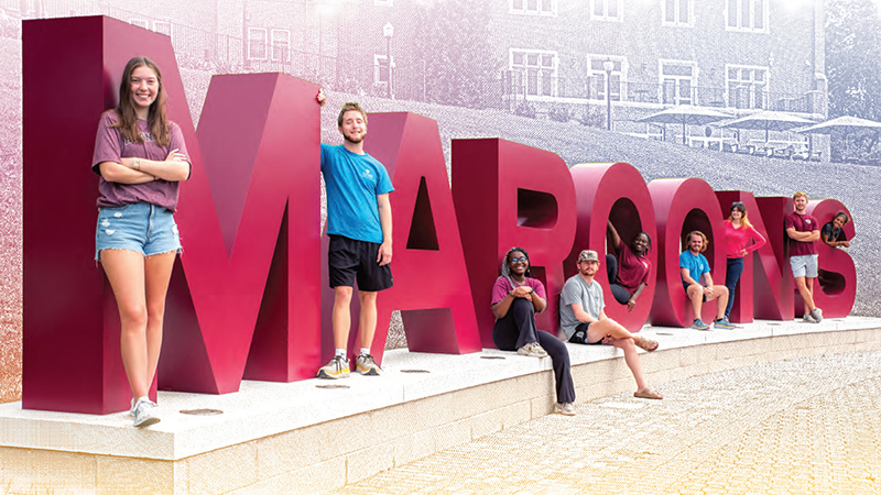 Students around the MAROONS letters 