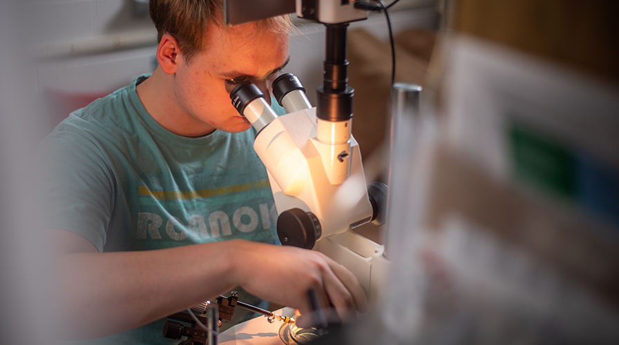 student looking through a microscope