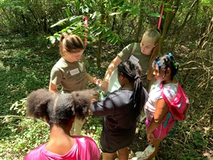 college students and children looking at leaves