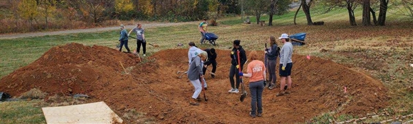 students digging rain garden