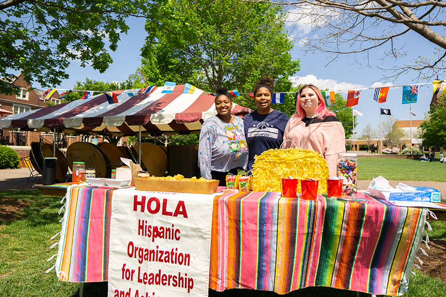 Students reading sign that reads "hola"