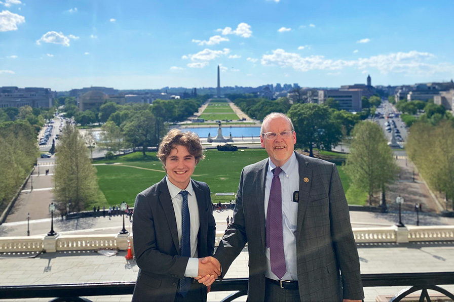 Luke Coburn shaking hands with Congressman Morgan Griffith with the Washington Monument in the background