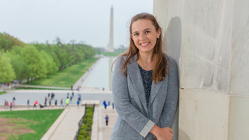 Washington Semester - student stands in front of Washington Monument