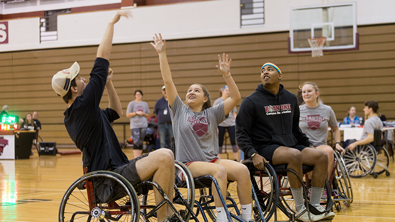 Students reaching for a ball during a game of wheelchair basketball