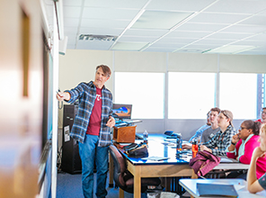 Professor pointing to board in front of a statistics class