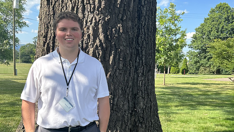 Andrew Chitwood smiling for a photo while wearing his internship ID badge