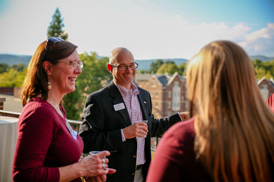 Alumni and parents chat during an on-campus event