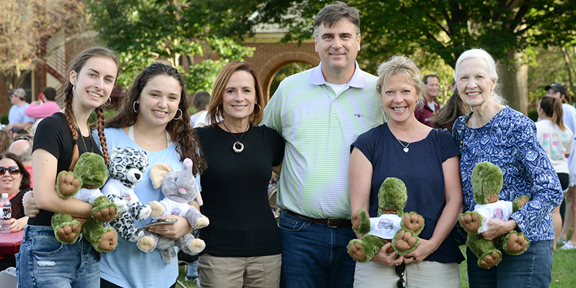 A family posing with their stuffed animals they made