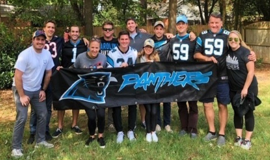 Picture of alumni with a North Carolina Panthers banner