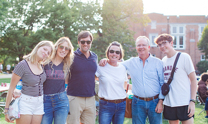 A smiling family on the quad during family weekend