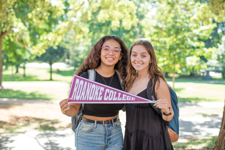 students holding Roanoke College pennant 