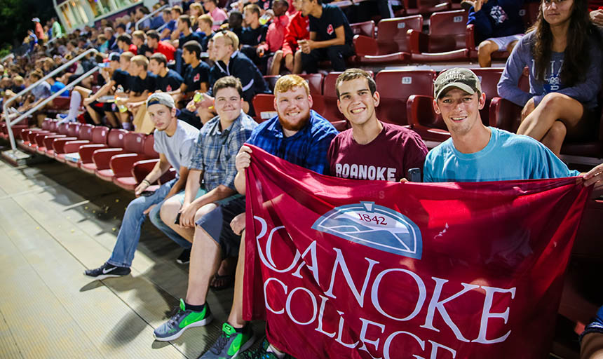 Students holding up a Roanoke College banner at a soccer game