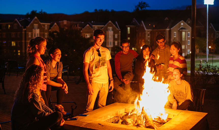 students standing around a fire pit