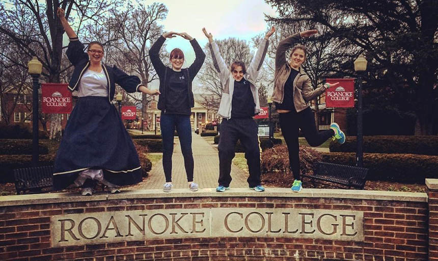 Students standing on the Roanoke College sign and spelling out "LOVE" for the scavenger hunt