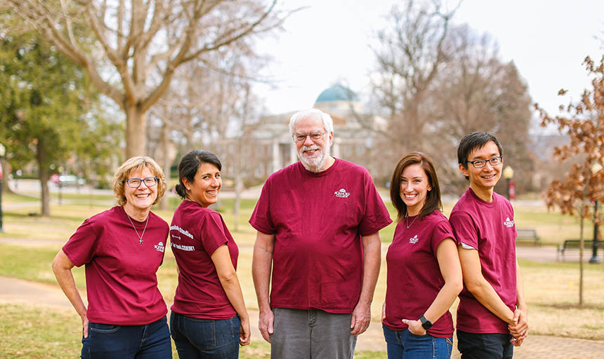 Professors outside smiling and laughing