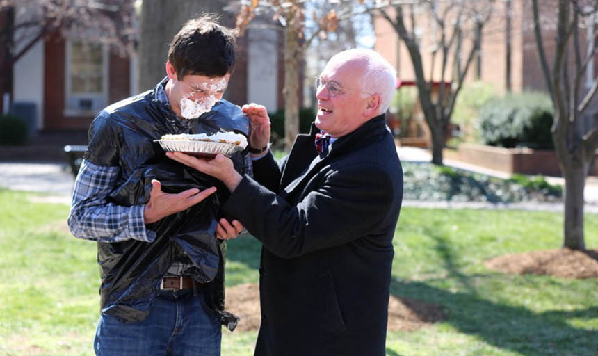 President Maxey shoving a pie in a professor's face