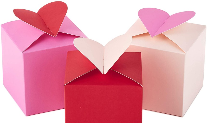 Pink and red boxes with paper hearts on top of them