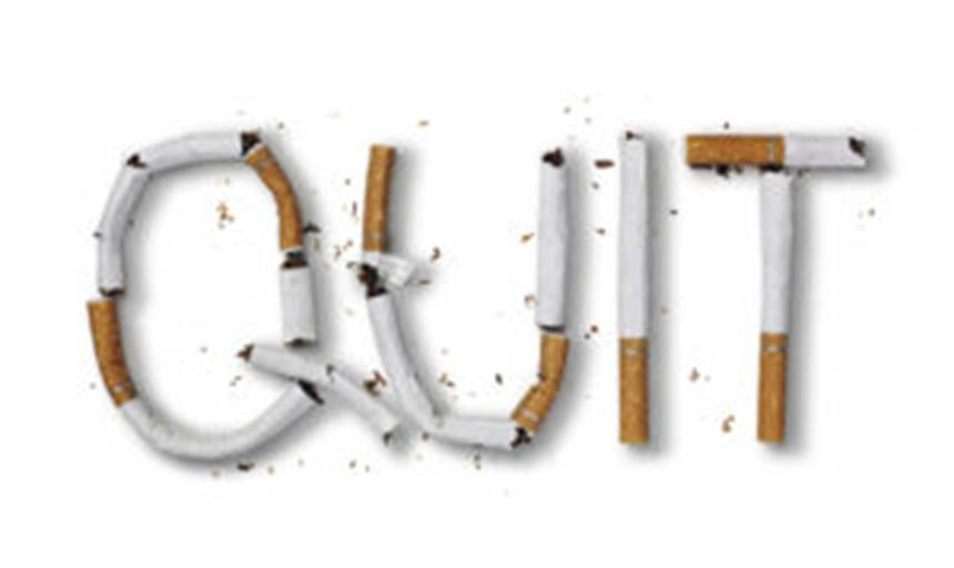 The word "quit" spelled out in burnt cigarettes