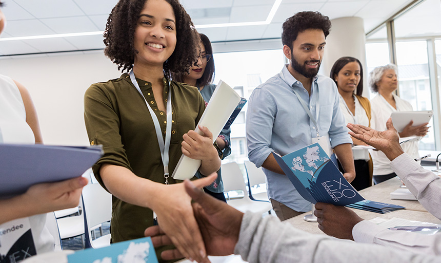 People smiling and shaking hands at a career fair