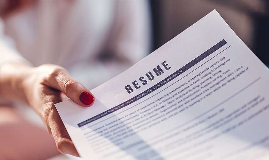 A person handing someone else a resume