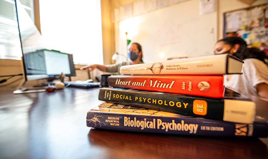 A professor and student talking over some books 