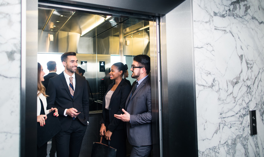 image of people in business wear talking on an elevator