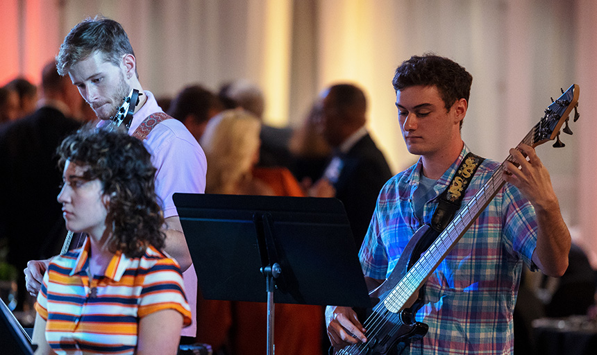 Students holding instruments perform at a past concert