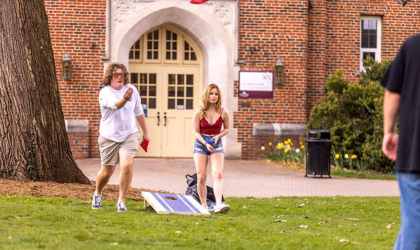 students playing cornhole on the back quad