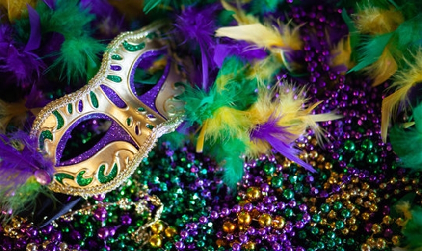 purple, gold, and green breads with festive mask and boa on top