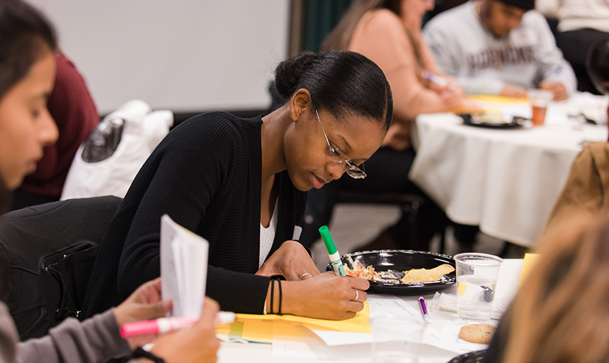 Student writing with a marker