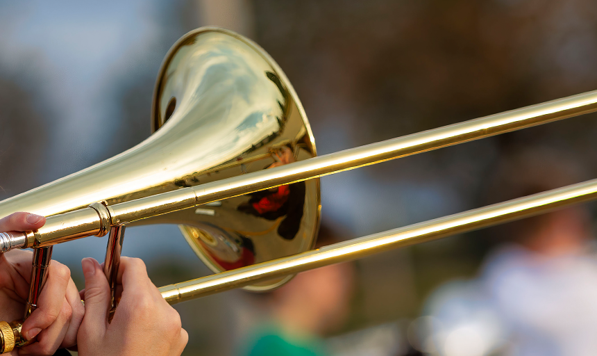 A trombone lifted in the air while being played