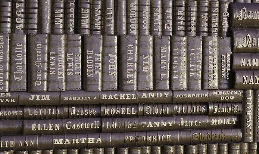 Closeup image of bronze sculpture made in the image of record books engraved with names