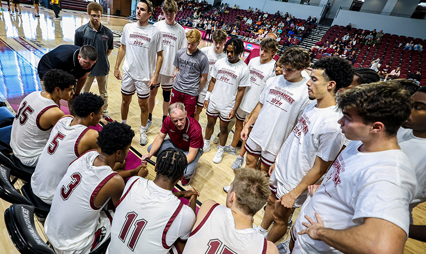 Basketball coach and team in a courtside huddle