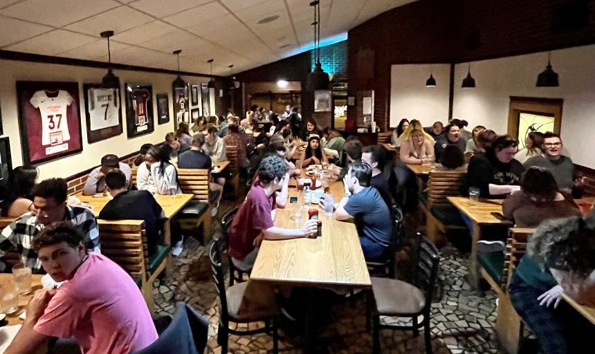 Students gathered around tables at a restaurant