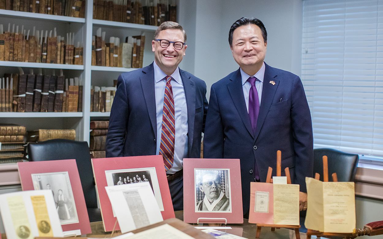 Ambassador Cho and President Shushok stand in Archives with Kim Kyusik memorabilia