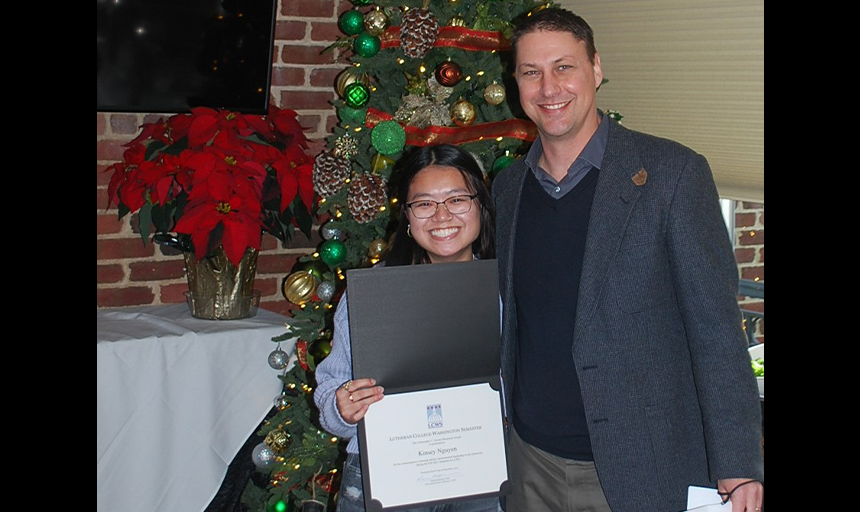 Student holding certificate and smiling