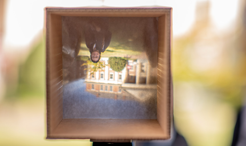 student poses for picture in camera obscura