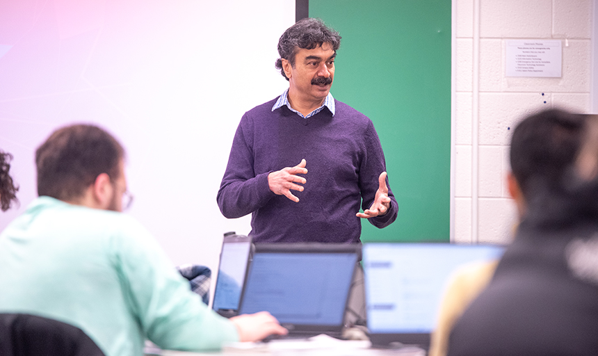 Professor talking to students in a classroom.