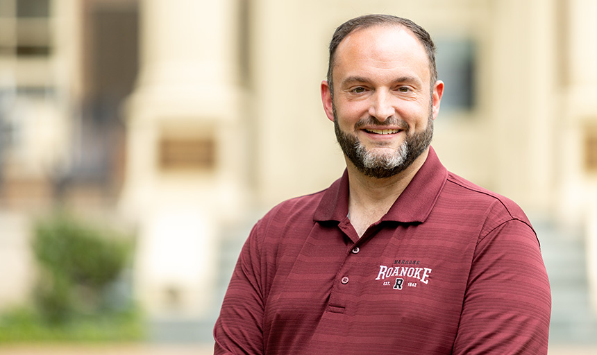 David Taylor pictured in a maroon Roanoke College shirt with campus in the background
