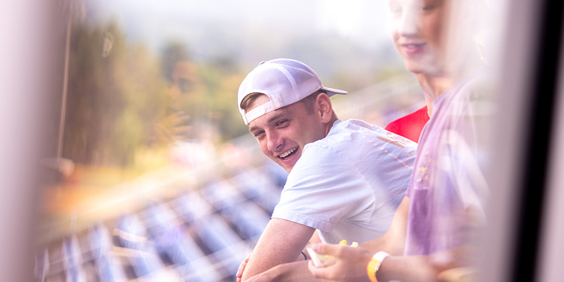 A student smiles while leaning against a bannister at a box suite of the Salem Red Sox