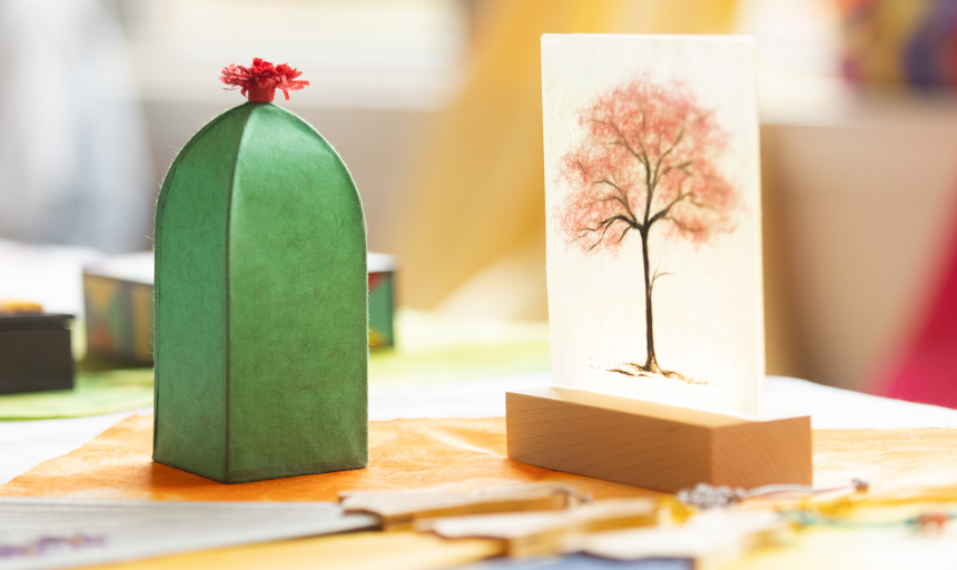 A tree painting and a cactus piece of art next to each other.