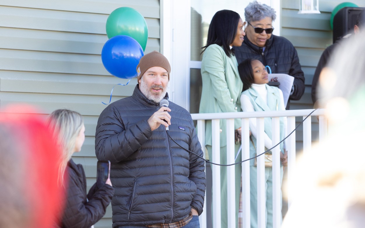 Jesse Griffin, holding a mircophone, addresses the crowd.