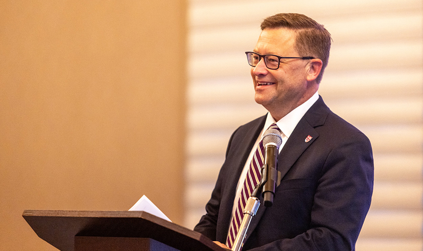 Close-up photo of President Shushok smiling while speaking at the podium